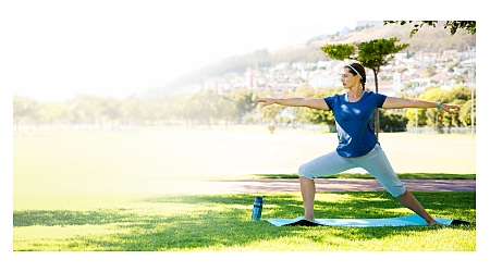 Frau beim Yoga mit dem TomTom Touch Fitness-Tracker.